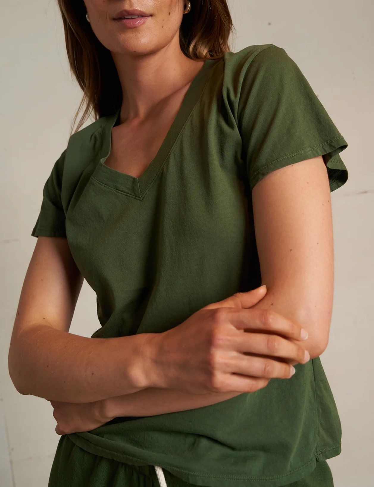 Woman wearing a green dress against a plain background